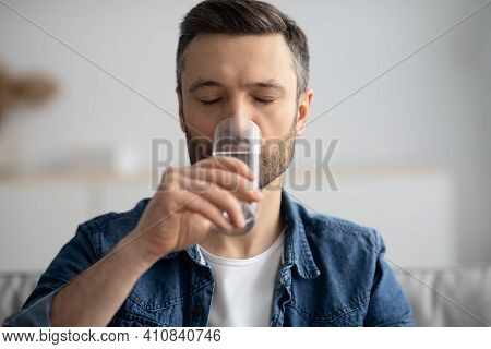 Closeup Of Middle-aged Man With Eyes Closed Drinking Spring Water At Home, Healthy Bearded Man Start