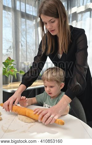 Mother With Toddler Son With Cochlear Implants Baking Donuts On Kitchen