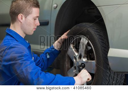 Mužské mechanik měnící auto kola s klíč