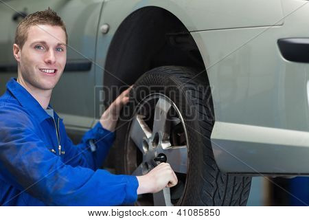 Portret młody mężczyzna mechanik, zmiana opon samochodu