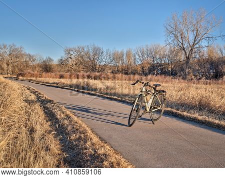 touring bicycle in late fall or winter scenery in sunset light on a bike trail in northern Colorado, recreation and commuting concept