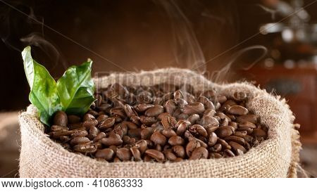 Falling Roasted Coffee Beans into Jute Bag, close-up.