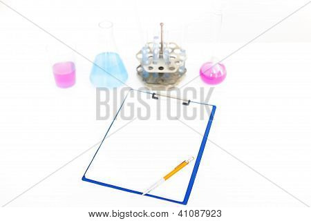 Chemical Flasks With Reagents And Clipboard Isolated Over White Background