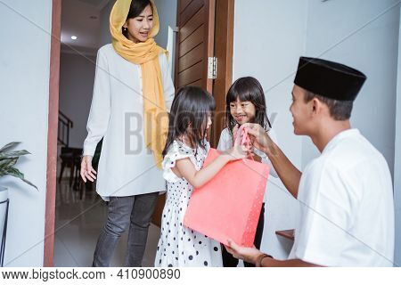 Muslim Father Giving A Gift To His Children On Eid Mubarak