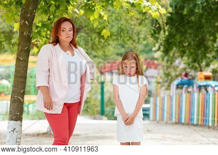 Family. A Distressed Mother And Daughter, Quarreling In The Park. The Concept Of Children's Whims An