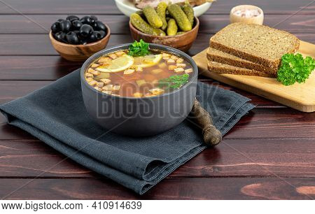 Bowl With Solyanka Or Soljanka, A And Sour Soup Of Russian And East Europa Origin, On Dark Wooden Ba