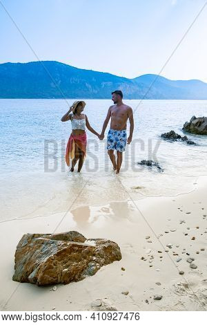 A Couple From Behind On The Backside Looking Out Over The Ocean Of Tropical Island, Men And Woman Va