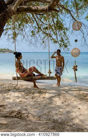 A Couple From Behind On The Backside Looking Out Over The Ocean Of Tropical Island, Men And Woman Va
