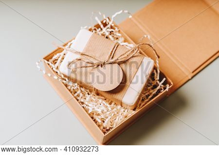 Soap In Craft Eco Gift Box Or Present Box With Bow On Gray Background With Mockup Label Tag. Copy Sp