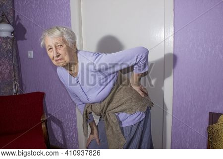 Elderly Senior  Woman With Pain Massaging Low Back  From Backache Discomfort. Diseases Of Older Peop