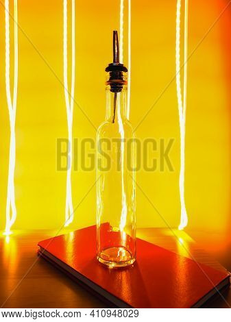 Small Narrow Bottle With Bartender Pourer On Table With Light Paiting Around