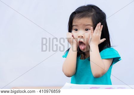Child Appears Shocked Or Bored. Children Pushes Her Cheek With Both Hands. Kids Sticks Out His Tongu