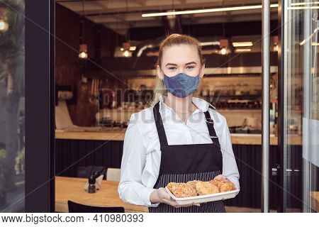 Small Business Owner Smiling And Standing At Entrance Of Open Restaurant While Reopening After Lockd