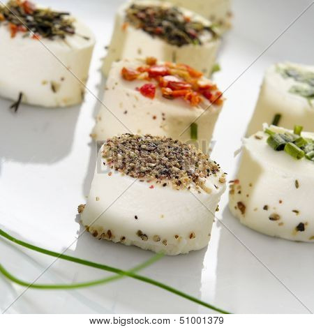 a plate with some different cheese canapes topped with different spices