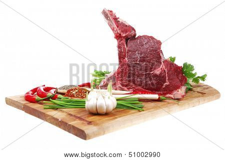 raw meat : fresh beef pork big rib piece with garlic and green stuff on wood isolated over white background