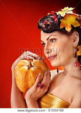 Woman holding autumn basket with fruit and vegetable.