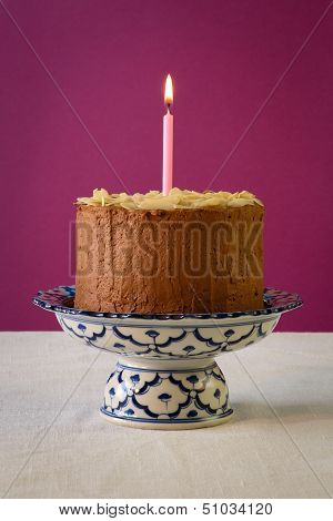 Chocolate Birthday Cake With Almond Flakes And Burning Candle