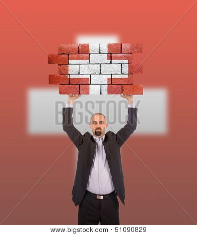 Businessman Holding A Large Piece Of A Brick Wall