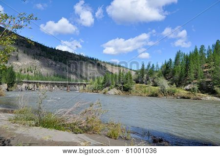 Bridge Over The Mountain River In Yakutia.