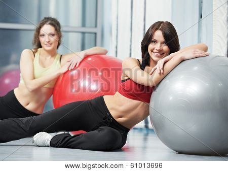 group of young smiling woman with finess ball in gym