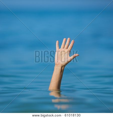 hand of drowning man in sea asking for help