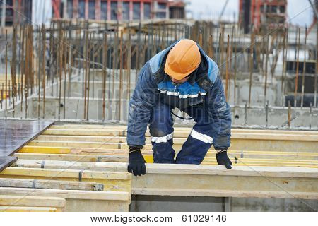 construction worker at construction site assembling falsework for concrete pouring