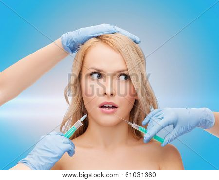 beauty and cosmetic surgery concept - woman face and beautician hands with syringes