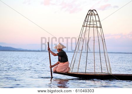 INLE LAKE, MYANMAR DECEMBER 12, 2013: Fishermen at Inle Lake, Shan State, Myanmar Intha people possess the leg-rowing style and the unique coop-like fishing equipment