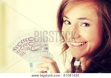 Happy young woman holding money