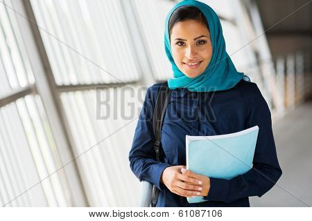 modern female middle eastern college student holding a book