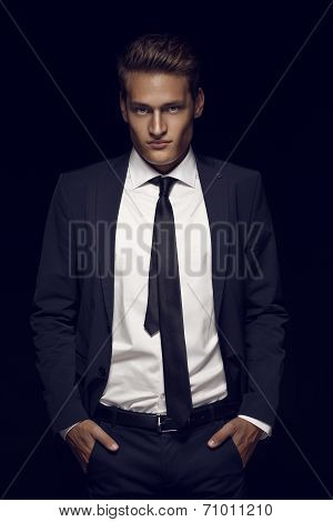 Cool Businessman Standing On Dark Background