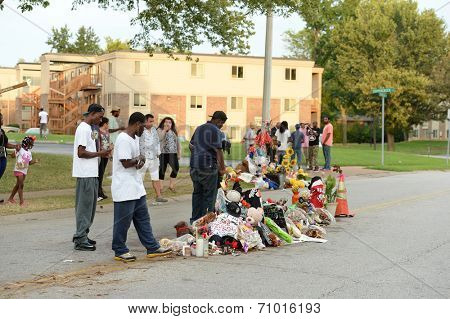 FERGUSON, MO/USA - AUGUST 30, 2014: A group gathers at makeshift memorial where black teenager Michael Brown was shot to death by police in Ferguson, Missouri.