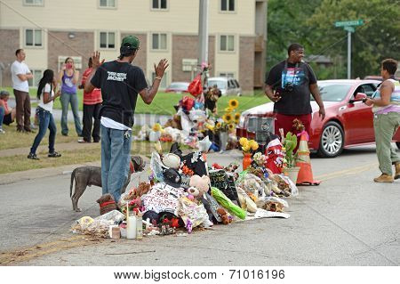 FERGUSON, MO/USA - AUGUST 30, 2014: A man raises hands at makeshift memorial where black teenager Michael Brown was shot to death by police in Ferguson, Missouri.