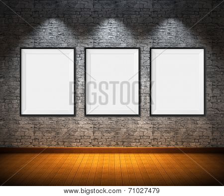 Art gallery. Blank picture frames on brick wall background.