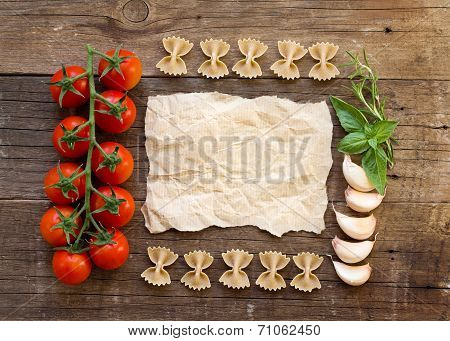 Pasta, Tomatoes, Garlic, Herbs And Paper On Wooden Background