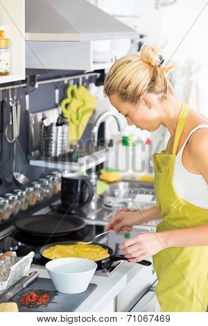 Young Mother Cooking at Home.
