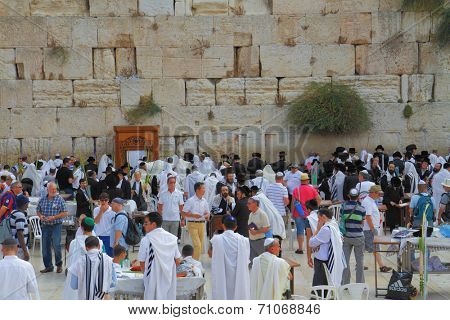 JERUSALEM, ISRAEL - SEPTEMBER 18, 2013: Sunny morning in the holiday of Sukkot. Religious Jews in white prayer shawls are going to pray at the Western Wall of the Temple