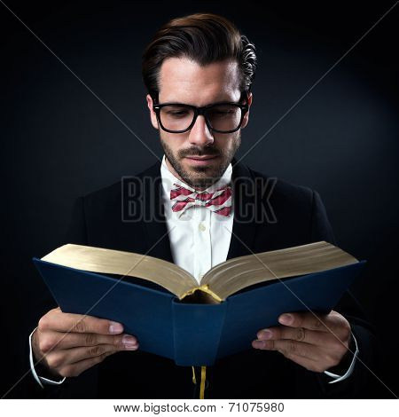 Intrigued Businessman With Glasses Reading A Book. Isolated On Black.