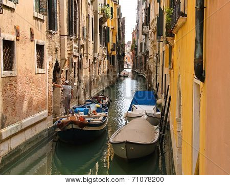 Builder With Construction Materials In  Boat Is Worth Innarrow Channel Near The House In Venice, Ita