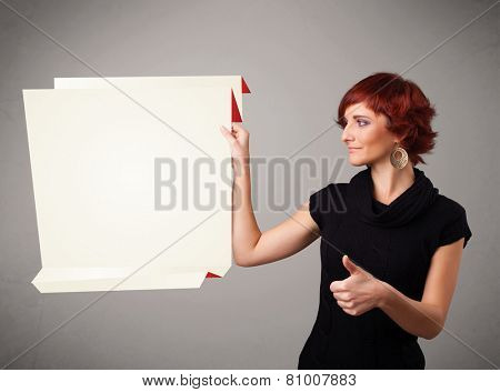 Baeutiful young woman holding white origami paper copy space