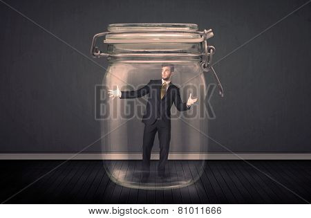 Businessman trapped into a glass jar concept on background
