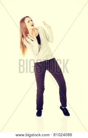 Beautiful cascaual woman is crouching from sth heavy above her.