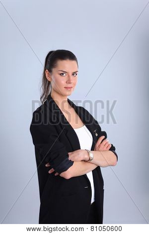 A young woman standing, isolated on graybackground