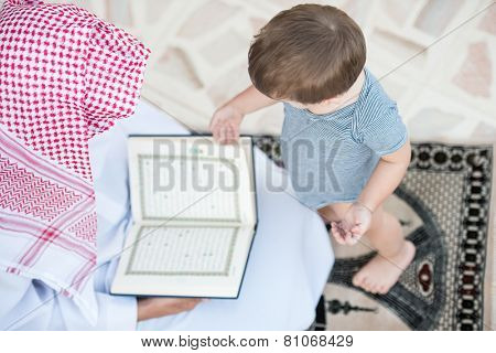 Young Arabic Muslim man reading Koran and praying