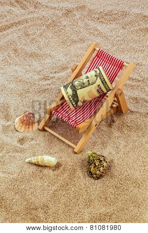 beach chair with dollars on the sandy beach. symbolic photo for cost of travel, vacation, holidays. save on vacation
