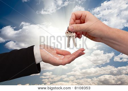 Man överlämnar nycklarna till kvinnliga moln och strålar