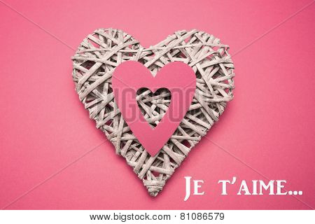 Wicker heart ornament with paper cut out against valentines love hearts