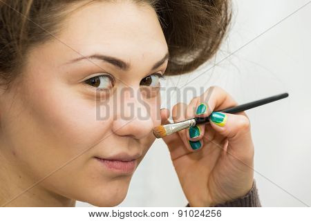 Application of powder on the model's face.