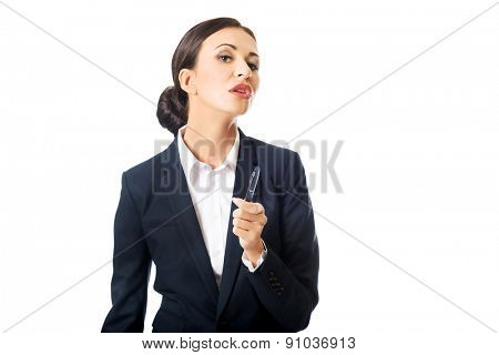 Photo of businesswoman holding pen, looking at the camera.