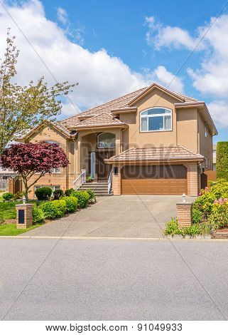 Luxury house with beautiful landscaping on a sunny day. Home exterior design.
